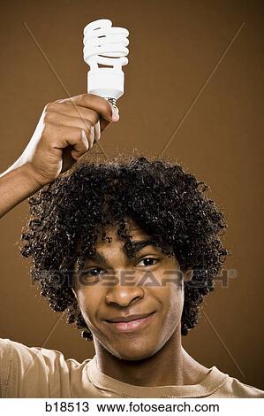 young man in a brown shirt holding light bulbs. View Large Photo Image Stock Image - young man in a brown shirt holding light bulbs.. Fotosearch