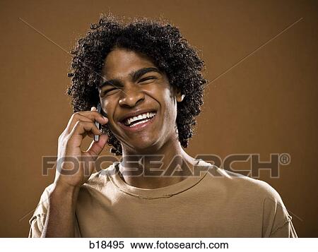 young man in a brown shirt on a cell phone. View Large Photo Image Stock Photography - young man in a brown shirt on a cell phone.. Fotosearch