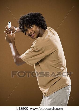 young man in a brown shirt playing a video game. View Large Photo Image Stock Image - young man in a brown shirt playing a video game.. Fotosearch