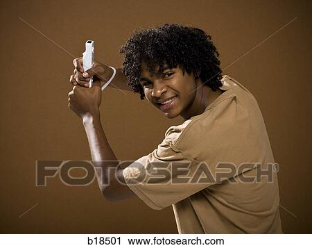 young man in a brown shirt playing a video game. View Large Photo Image Stock Image - young man in a brown shirt playing a video game.. Fotosearch