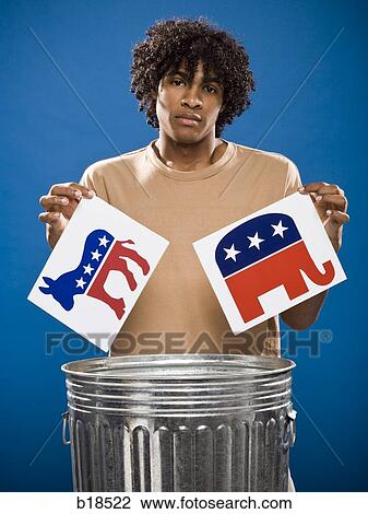 Stock Image - young man in a brown shirt throwing away a political party symbol.. Fotosearch