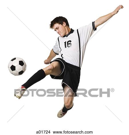 Young man kicking a soccer ball. View Large Photo Image Picture - Young man kicking a soccer ball.. Fotosearch