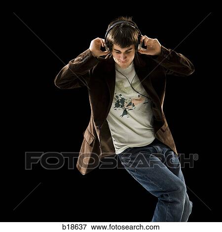 Young man listening to earphones and dancing. View Large Photo Image Stock Photo - Young man listening to earphones and dancing.. Fotosearch