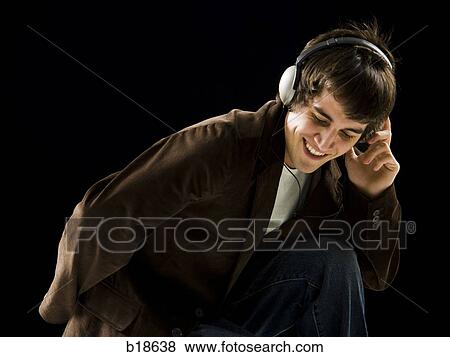 Young man listening to earphones and dancing. View Large Photo Image Stock Photo - Young man listening to earphones and dancing.. Fotosearch