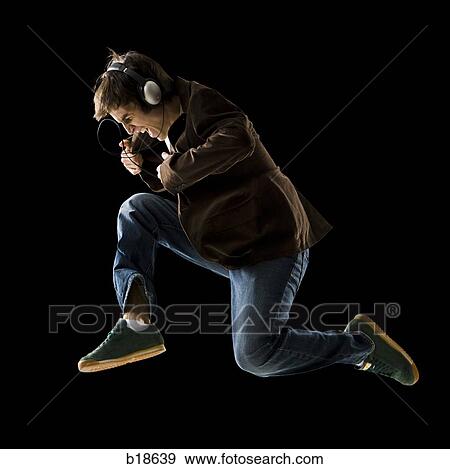 Young man listening to earphones and dancing. View Large Photo Image Stock Photo - Young man listening to earphones and dancing.. Fotosearch