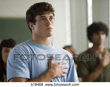 Young man with hand over heart. View Large Photo Image Stock Photo - Young man with hand over heart.. Fotosearch