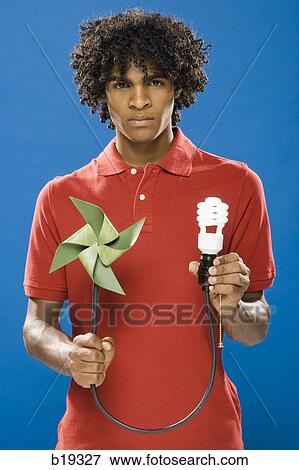 young man with pinwheel and energy saving light bulb View Large Photo Image Stock Photo - young man with pinwheel and energy saving light bulb. Fotosearch