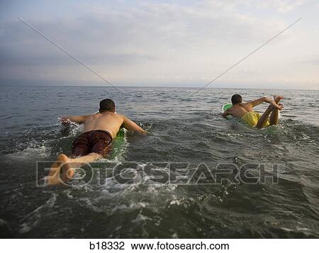 Young men in the water with surfboards. View Large Photo Image Stock Image - Young men in the water with surfboards.. Fotosearch
