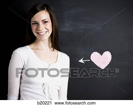 Stock Image - young woman against a chalkboard. Fotosearch