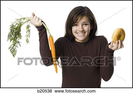 young woman choosing between a carrot and a donut View Large Photo Image Stock Photo - young woman choosing between a carrot and a donut. Fotosearch