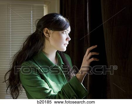 young woman looking out a window View Large Photo Image Stock Photography - young woman looking out a window. Fotosearch