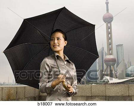 Stock Photo - Young woman under an umbrella.. Fotosearch