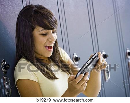 young woman with a handheld video game View Large Photo Image Stock Photo - young woman with a handheld video game. Fotosearch