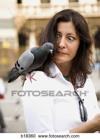 Stock Image - Young woman with birds on her head and shoulder.. Fotosearch