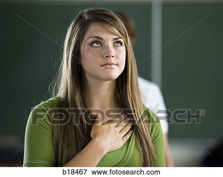 Stock Photo - Young woman with hand over heart.. Fotosearch