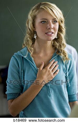 Stock Photo - Young woman with hand over heart.. Fotosearch
