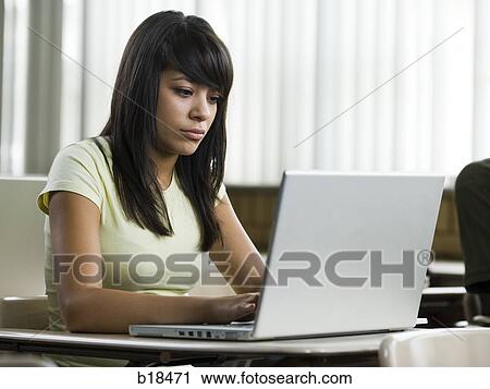 Young woman working on a notebook computer. View Large Photo Image Stock Image - Young woman working on a notebook computer.. Fotosearch