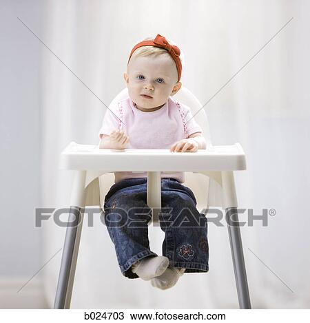 Stock Image - baby girl in a high chair. Fotosearch