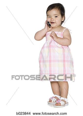 baby girl in a pink dress holding a cell phone View Large Photo Image Picture - baby girl in a pink dress holding a cell phone. Fotosearch