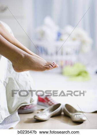 Stock Image - bare feet hanging off the bed. Fotosearch
