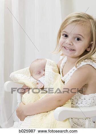 Stock Photo - big sister holding her newborn brother. Fotosearch