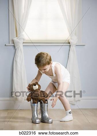 boy putting a teddy bear in his boots View Large Photo Image Stock Photograph - boy putting a teddy bear in his boots. Fotosearch