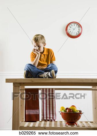 boy sitting on a kitchen table View Large Photo Image Stock Photography - boy sitting on a kitchen table. Fotosearch