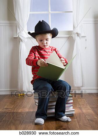 boy wearing a cowboy hat reading a book View Large Photo Image Stock Image - boy wearing a cowboy hat reading a book. Fotosearch