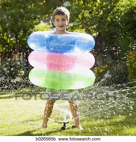 Stock Image - boy with three inner tubes. Fotosearch