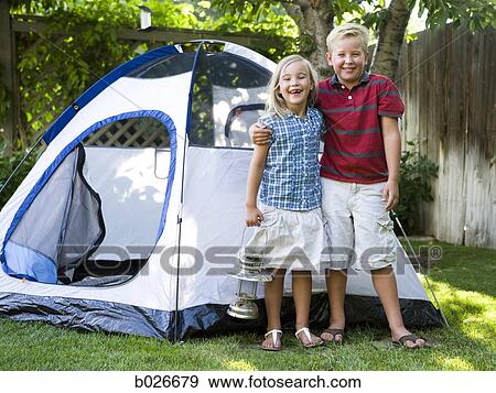brother and sister standing in front of a tent in the backyard View Large Photo Image Stock Photo - brother and sister standing in front of a tent in the backyard. Fotosearch