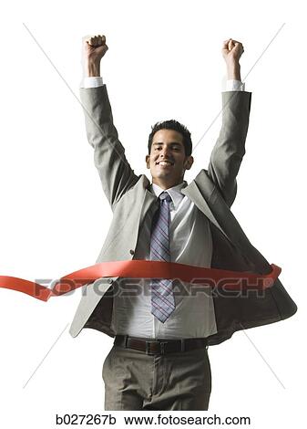businessman crossing a finish line of a red ribbon with arms raised in the air triumphantly View Large Photo Image Stock Image - businessman crossing a finish line of a red ribbon with arms raised in the air triumphantly. Fotosearch