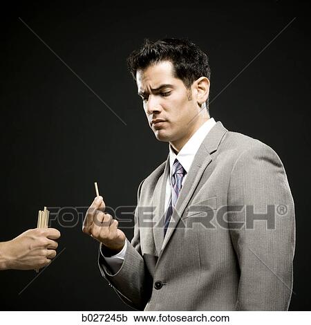 Stock Image - businessman drawing straws. Fotosearch