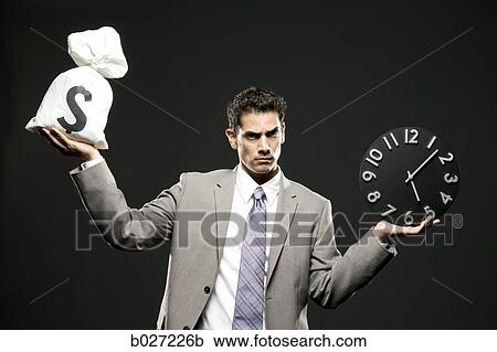 businessman holding a clock and a bag of money View Large Photo Image Stock Image - businessman holding a clock and a bag of money. Fotosearch