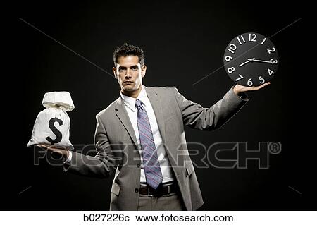 businessman holding a clock and a bag of money View Large Photo Image Stock Image - businessman holding a clock and a bag of money. Fotosearch