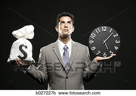 businessman holding a clock and a bag of money View Large Photo Image Stock Image - businessman holding a clock and a bag of money. Fotosearch