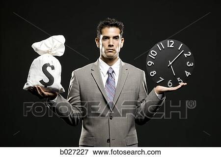 businessman holding a clock and a bag of money View Large Photo Image Stock Photo - businessman holding a clock and a bag of money. Fotosearch