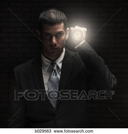 Stock Image - businessman holding a flashlight. Fotosearch