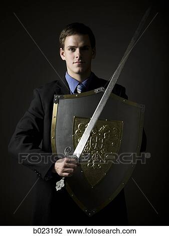 businessman holding a sword and shield View Large Photo Image Stock Image - businessman holding a sword and shield. Fotosearch
