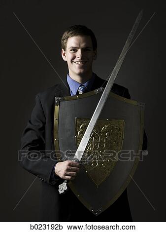 businessman holding a sword and shield View Large Photo Image Stock Image - businessman holding a sword and shield. Fotosearch