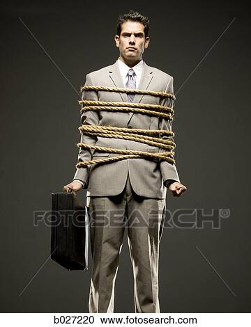 businessman in a full suit tied up with a rope around his mid section View Large Photo Image Stock Image - businessman in a full suit tied up with a rope around his mid section. Fotosearch