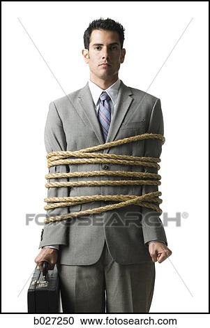 Stock Image - businessman in a full suit tied up with a rope around his mid section. Fotosearch