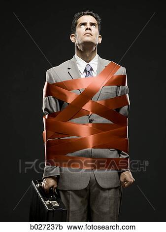 businessman wrapped up with red tape View Large Photo Image Stock Image - businessman wrapped up with red tape. Fotosearch