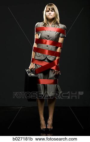 Stock Image - businesswoman all wrapped up in red ribbon. Fotosearch