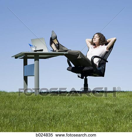 Stock Photography - businesswoman at her desk in a grassy field. Fotosearch