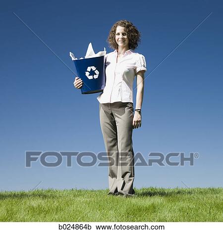 Stock Image - businesswoman holding a recycling bin. Fotosearch