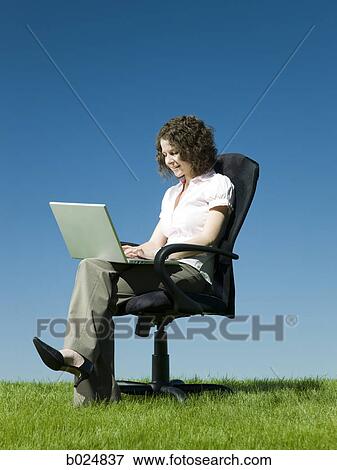 businesswoman using her laptop in a busy field View Large Photo Image Stock Photo - businesswoman using her laptop in a busy field. Fotosearch