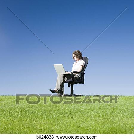 businesswoman using her laptop in a busy field View Large Photo Image Stock Photo - businesswoman using her laptop in a busy field. Fotosearch