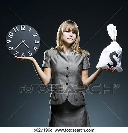 Stock Image - businesswoman weighing time versus money. Fotosearch