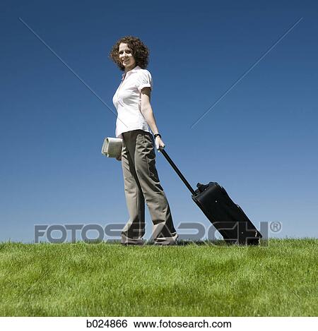 businesswoman with a rolling suitcase View Large Photo Image Stock Photograph - businesswoman with a rolling suitcase. Fotosearch