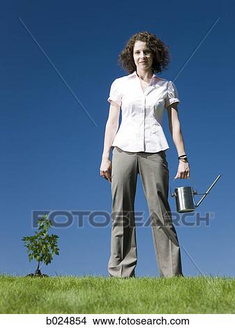 Picture - businesswoman with a watering can. Fotosearch